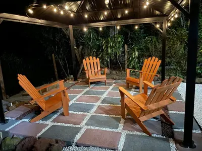 three wooden chairs sitting on a patio under a gazebo at Parque Nacional Volcán Poás Cabaña Abby in Bajos Tigre