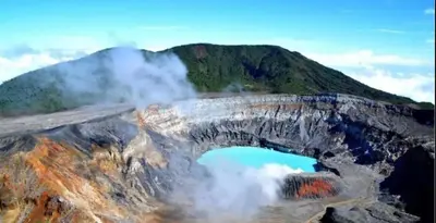 an aerial view of a mountain with a blue lake at Parque Nacional Volcán Poás Cabaña Abby in Bajos Tigre