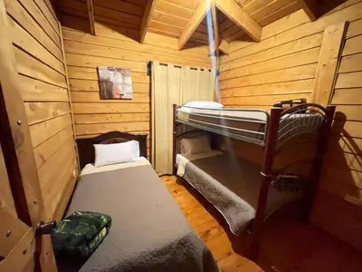 a room with two bunk beds in a cabin at Parque Nacional Volcán Poás Cabaña Abby in Bajos Tigre