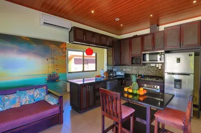 a kitchen with a table and some chairs in a room at Ojochal Magnificent Ocean View in Ojochal