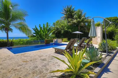 a patio with two chairs and a swimming pool at Ojochal Magnificent Ocean View in Ojochal