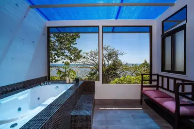 a large bathroom with a tub and large windows at Ojochal Magnificent Ocean View in Ojochal
