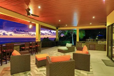a patio with chairs and a bar with a view of the ocean at Ojochal Magnificent Ocean View in Ojochal