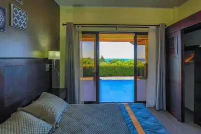a bedroom with a bed and a view of the ocean at Ojochal Magnificent Ocean View in Ojochal