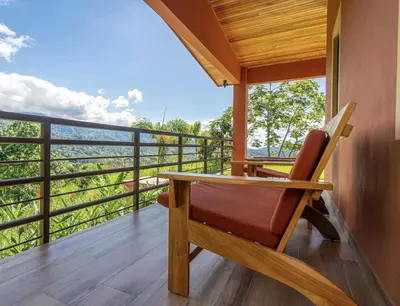 a room with a table and a chair on a balcony at Villa Roca Ocean to Mountain Views - by Pura Villas in Ojochal