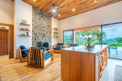 an open living room with a stone wall at Villa Roca Ocean to Mountain Views - by Pura Villas in Ojochal
