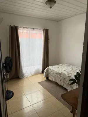 a bedroom with a bed and a window at Homestay in Quepos