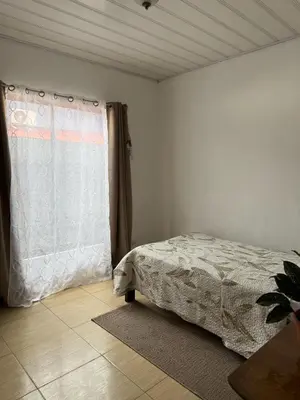 a bedroom with a bed and a window at Homestay in Quepos