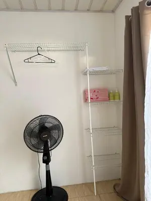 a black fan in a room with a white wall at Homestay in Quepos