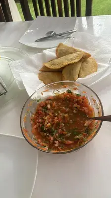 a bowl of food on a table with a plate of chips at Homestay in Quepos