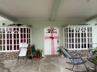 a room with a pink door and chairs in it at Homestay in Quepos