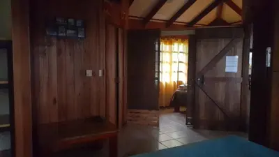 a room with wooden walls and a door and a bedroom at Las Brisas del Sur in Ojochal