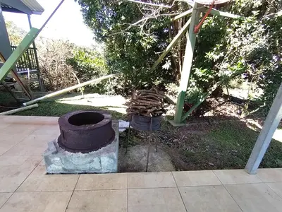 a brick stove in a yard with a tree at Casa árbol in Aguas Zarcas