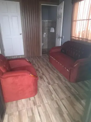 a living room with a red couch and a chair at Casa árbol in Aguas Zarcas