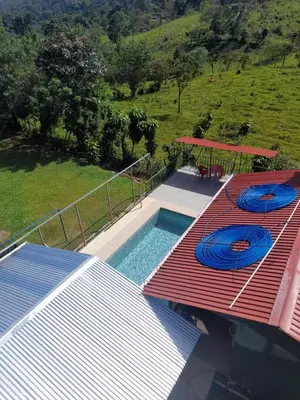 a swimming pool with two blue frisbees on a deck at Casa árbol in Aguas Zarcas