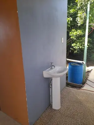 a bathroom with a sink and a bucket at Casa árbol in Aguas Zarcas