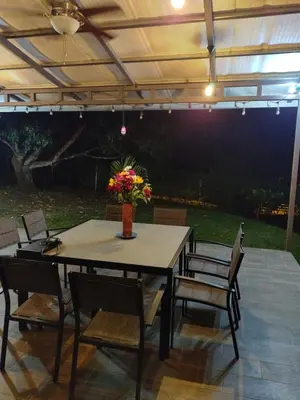 a patio with a table and chairs under a pergola at Casa Mangos in Orotina