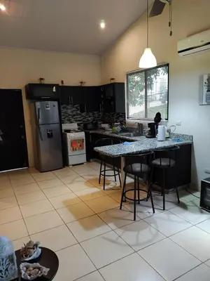 a kitchen with a table and chairs in a room at Casa Mangos in Orotina