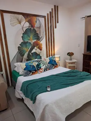 a bedroom with a large bed with a green blanket at Cabañas Mantas in Tarcoles