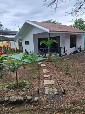 a house with a garden in front of it at Cabañas Mantas in Tarcoles