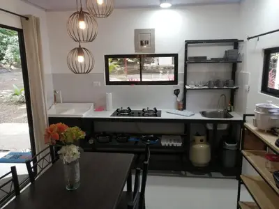 a kitchen with a stove and a counter top at Cabañas Mantas in Tarcoles