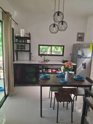 a kitchen with a table and chairs and a refrigerator at Cabañas Mantas in Tarcoles