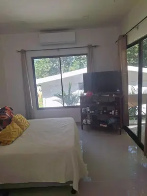 a bedroom with a bed and a flat screen tv at Cabañas Mantas in Tarcoles