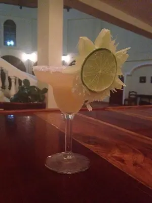 a drink with a lime on top of a bar at Hotel Delfin Playa Bejuco in Esterillos Este