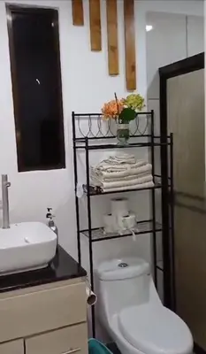 a bathroom with a white toilet and a sink at Cabañas Mantas in Jacó
