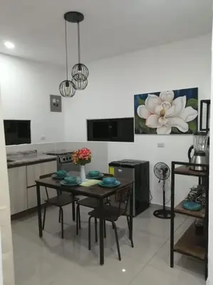 a kitchen with a table and chairs in a room at Cabañas Mantas in Jacó