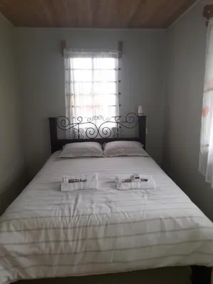 a bedroom with a bed with two towels on it at Casa Lapas. in Aguas Zarcas