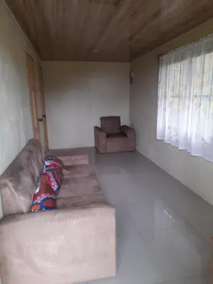 a living room with a couch and a chair at Casa Lapas. in Aguas Zarcas
