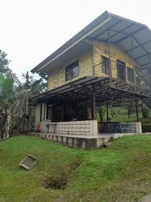 a large yellow house with a large balcony at Casa Lapas. in Aguas Zarcas