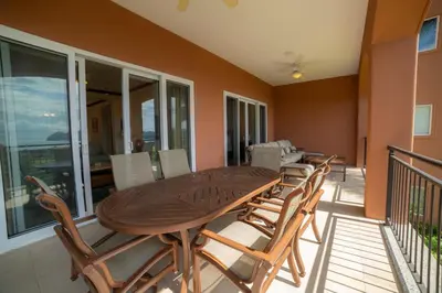 a wooden table and chairs on a balcony at AltaVista 2C 3 bdr Ocean View in Los Suenos in Herradura