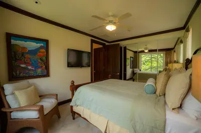 a bedroom with a bed and a couch and a tv at AltaVista 2C 3 bdr Ocean View in Los Suenos in Herradura