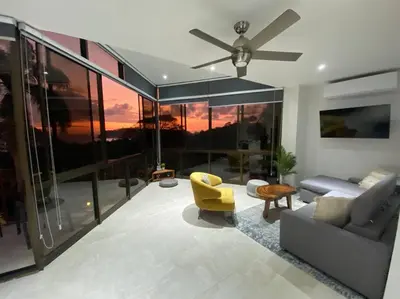 a living room with a couch and a ceiling fan at Modern condo with stunning ocean views in Samara in Sámara