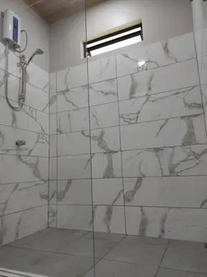 a bathroom with a shower with a marble wall at Mandy Loft -40MB wifi -8 miles from La Fortuna in San Ramón