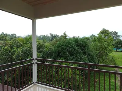 a screened in porch with a view of a yard at Mandy Loft -40MB wifi -8 miles from La Fortuna in San Ramón