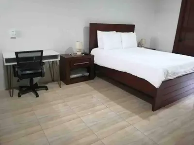 a bedroom with a bed and a desk and a chair at Mandy Loft -40MB wifi -8 miles from La Fortuna in San Ramón