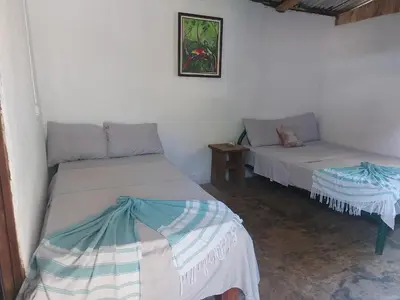 a room with two beds and a table in it at Anez Cabin'S in Cabuya