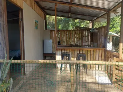 a patio with two chairs and a bar on a house at Anez Cabin'S in Cabuya