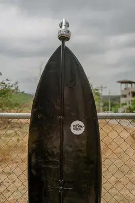 a boat sitting on top of a fence at Capsule Pupa House in Tamarindo