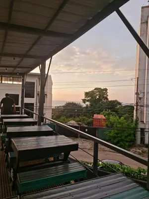 a row of wooden benches sitting on top of a building at Capsule Pupa House in Tamarindo
