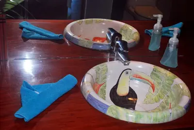 a bathroom counter with a sink and two dishes at Rafiki Beach Camp in Matapalo