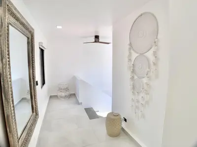 a white hallway with a mirror and a staircase at Modern Beachfront Paradise - Hermosa Palms 8 in Playa Hermosa