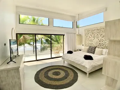 a bedroom with a bed and a large window at Modern Beachfront Paradise - Hermosa Palms 8 in Playa Hermosa