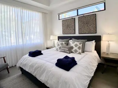 a bedroom with a large bed with blue towels on it at Modern Beachfront Paradise - Hermosa Palms 8 in Playa Hermosa