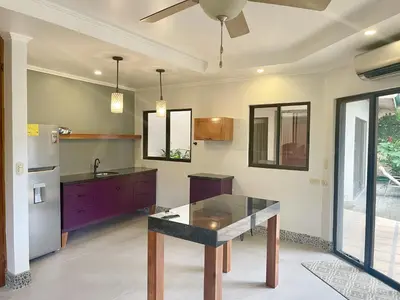 a kitchen with a table and a ceiling fan at Villa Arenas- Private Pool & Easy Beach Access in Jaco in Jacó