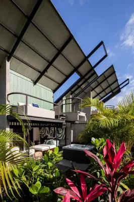 a patio with plants and a building with awning at BAUMA in Fortuna