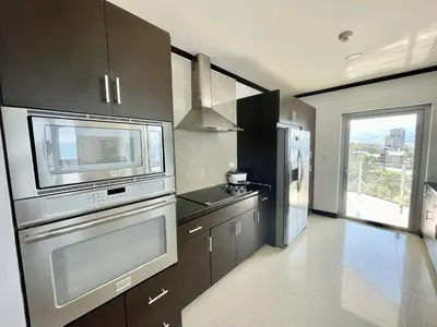 a kitchen with a microwave and a stove top oven at Ocean View, Luxury Penthouse at Diamonte del Sol 702N in Jacó